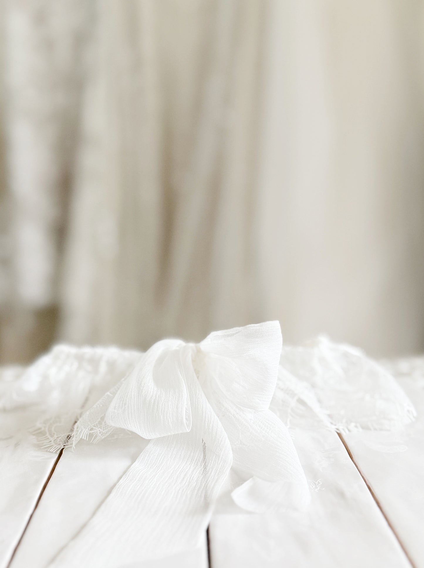 Close-up of a soft white lace wedding garter with a silk bow